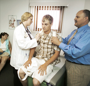 University of North Dakota medical student Rachel Aufforth and Robert Beattie MD check out a patients injured shoulder at the West River Regional Medical Center in rural Hettinger ND a town of 1