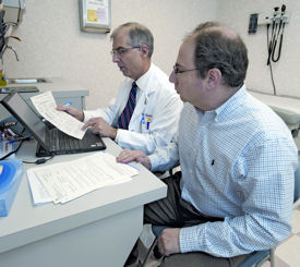 Allan L Crimm ACP Member at left reviews lab results and self-management goals with a patient as one aspect of services provided in a patient-centered medical home