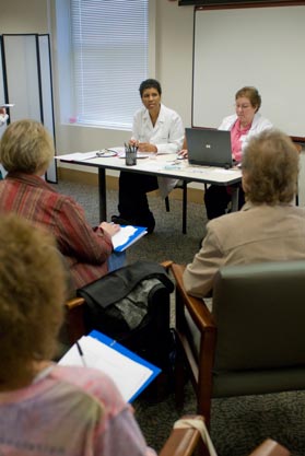 Karen Cooper DO on left guides patients through weight loss techniques at a shared medical appointment Ruth Jerkins RN takes notes on a computer as Dr Cooper speaks with each patient